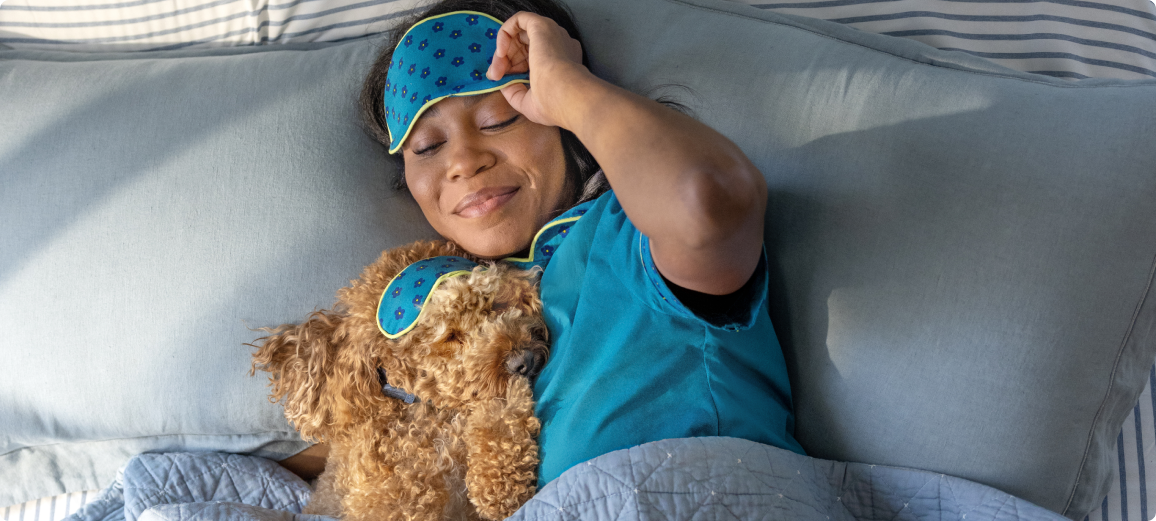 Hond rust met baasje in bed